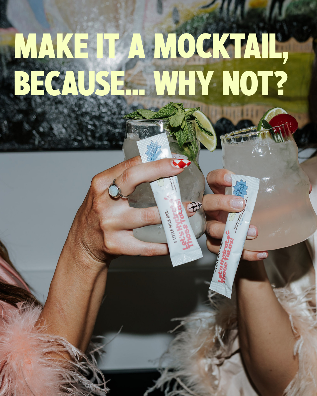 Two moms toasting electrolyte mocktails with garnish while holding Let's Hydrate Those Tatas coconut water drink mix sticks