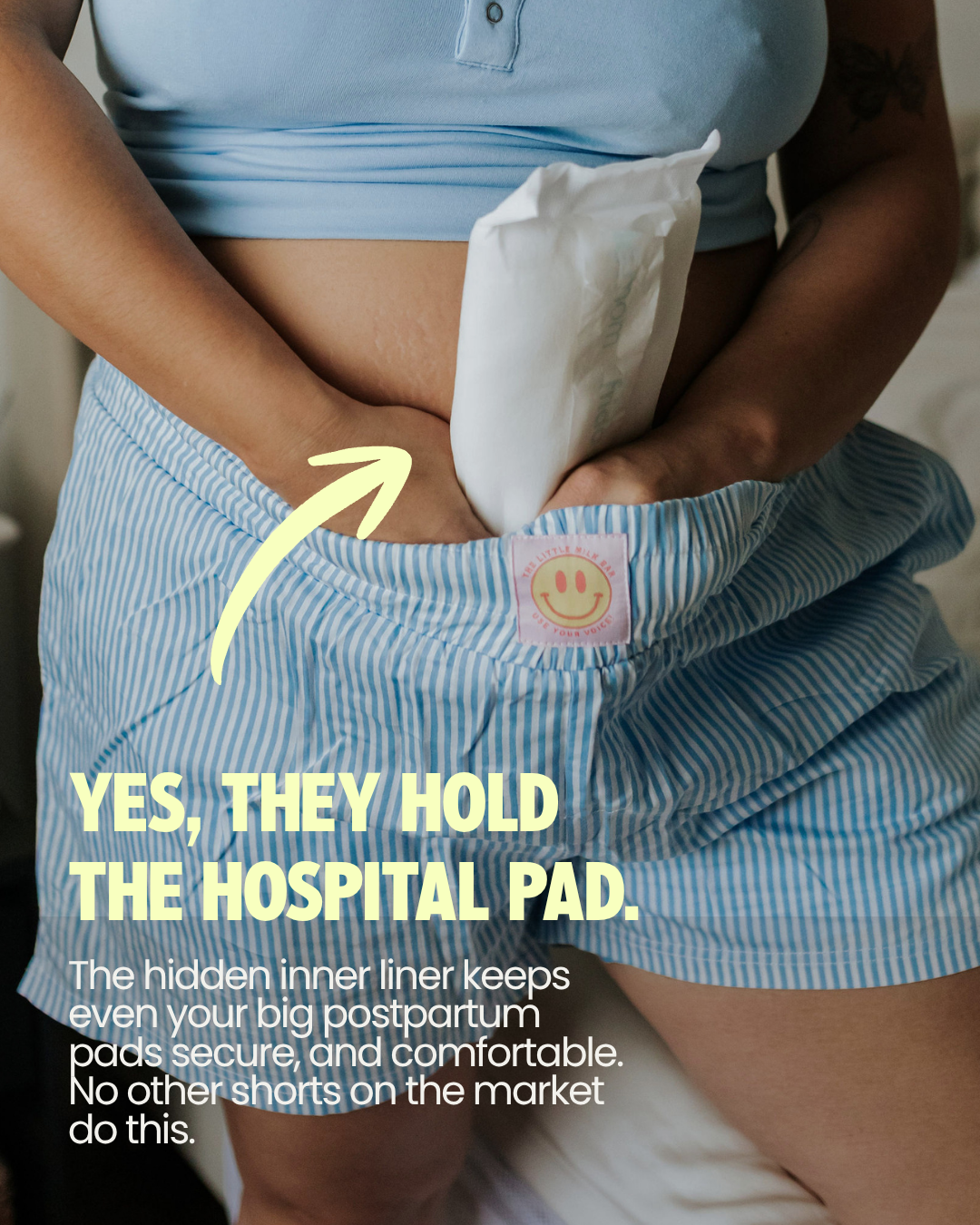 Mom tucking a hospital postpartum pad into the hidden inner liner of the Postpartum Boxer Shorts, which holds even large pads securely with no underwear needed